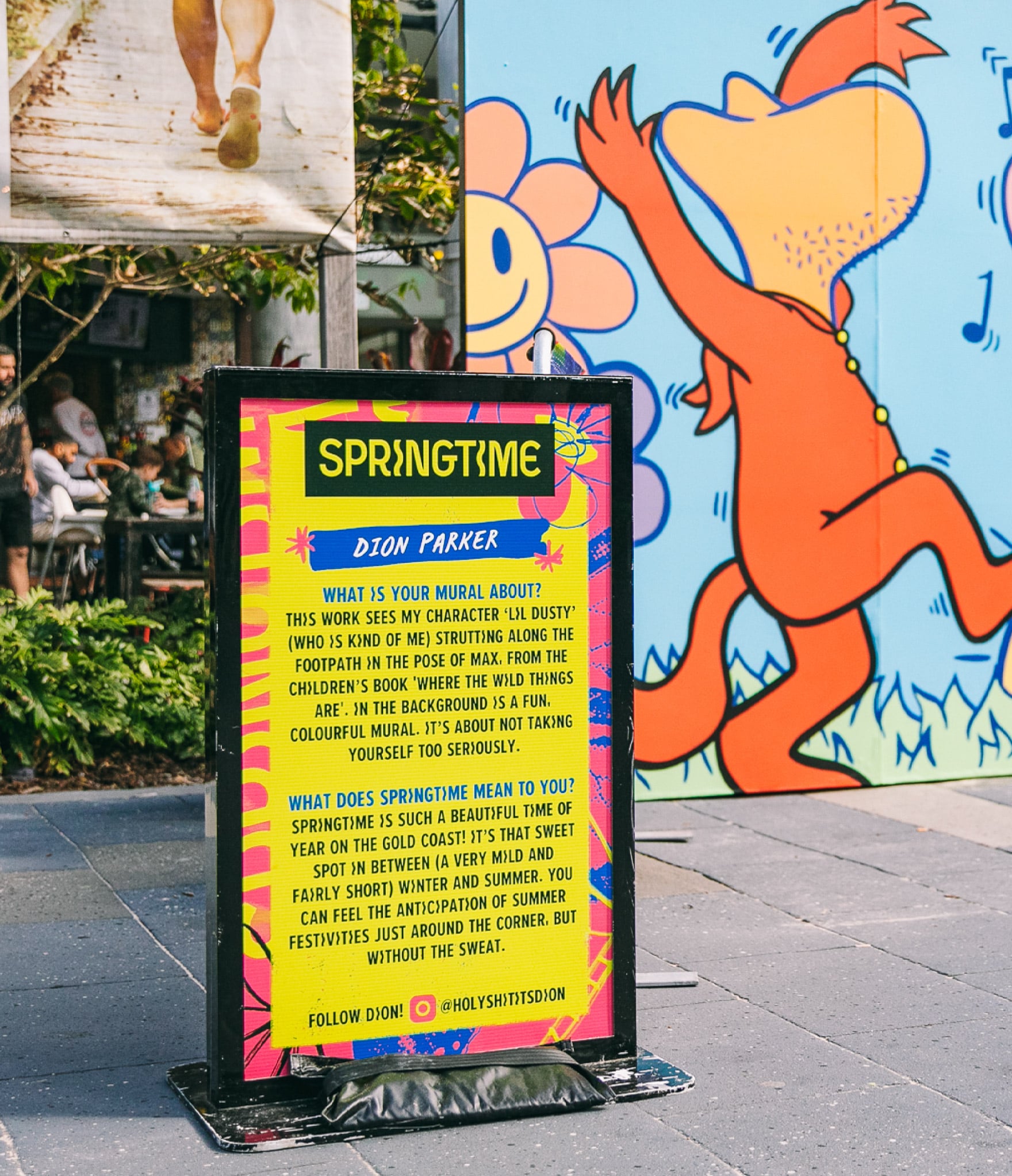 photo of a sign featuring Springtime branding and information about mural by respective artist